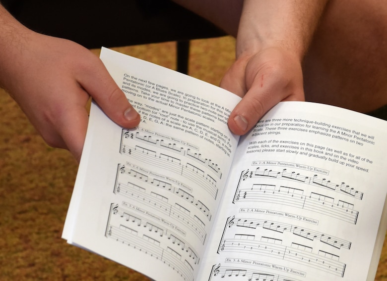 Airman 1st Class Colton Harris, 39th Communications Squadron client systems technician, holds an introduction to guitar book during a guitar class May 29, 2019, at Incirlik Air Base, Turkey. The guitar class is one way for Airmen to come together, step away from work and destress. (U.S. Air Force photo by Staff Sgt. Trevor Rhynes)