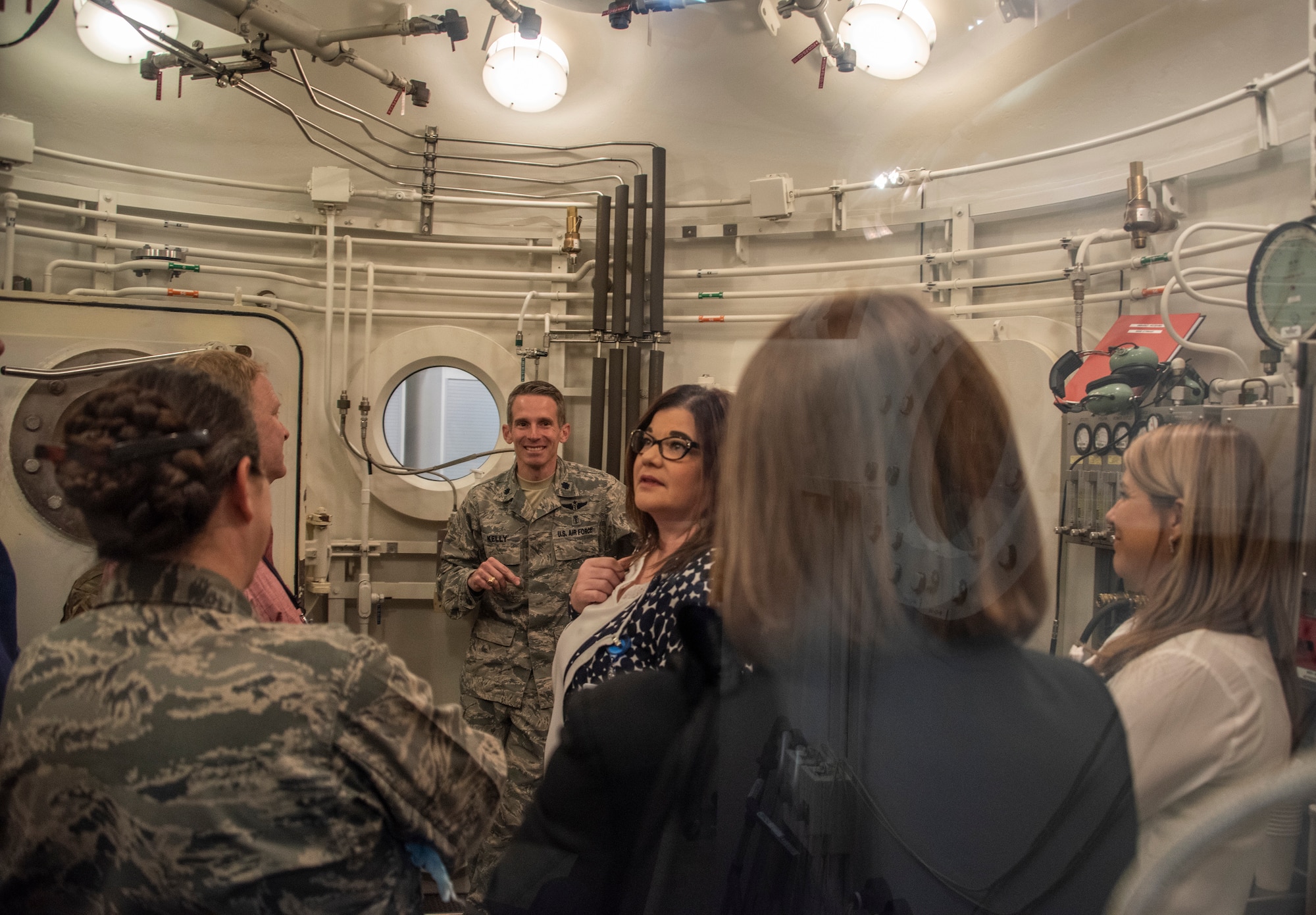 U.S. Air Force Lt. Col. Jason Kelly, center, 60th Aerospace Medicine Squadron, explains how the hyperbaric oxygen treatment chamber works, at David Grant USAF Medical Center April 17, 2019, at Travis Air Force Base, California. Registered nurses from North Bay Healthcare Medical Center and the University of California Davis Medical Center spent the day touring several departments at DGMC to observe how their military counterparts conduct day-to-day operations. (U.S. Air Force photo by Heide Couch)
