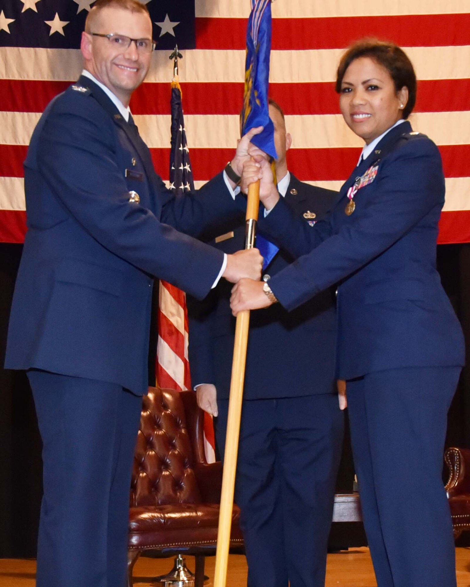 Col. Phil Heseltine, 931st Air Refueling Wing commander, hands the guidon to Lt. Col. Mei-Ling Taylor, incoming 931st Aerospace Medicine Squadron commander, during an assumption of command ceremony June 1, 2019, McConnell Air Force Base, Kan.  Previously, Taylor was the senior administrator for the 927th Aeromedical Staging Squadron at Macdill Air Force Base, Fla.