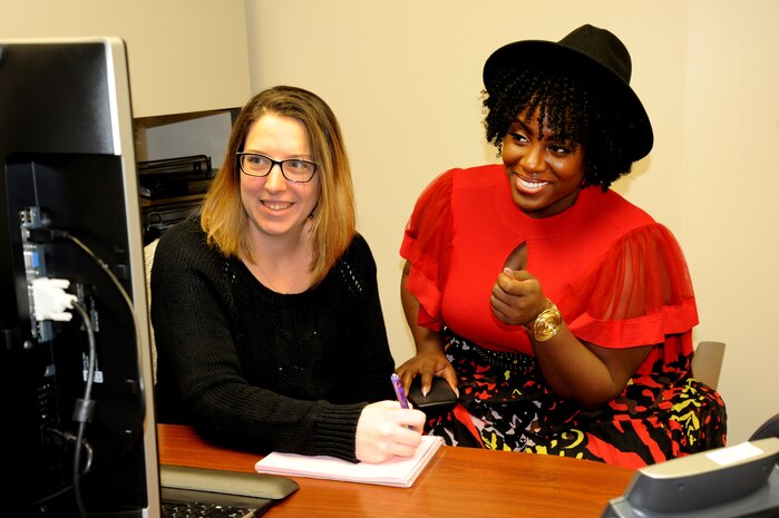 Sharonda Grandberry, Army veteran and contract specialist with the U.S. Army Engineering and Support Center, Huntsville, selected as the 2019 Face of Queen Size Magazine, an award-winning monthly print and digital publication dedicated to servicing the full-figured industry. Here, she discusses a proposed contract with co-worker, Jasmine Reason. (Photo by David San Miguel)