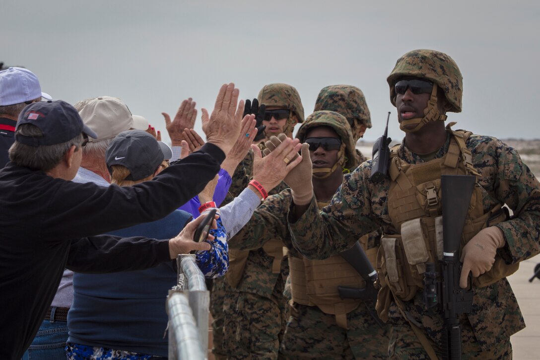 U.S. Marines with Marine Corps Air Station (MCAS) Yuma, high-five spectators during the 2019 Yuma Airhow hosted by Marine Corps Air Station (MCAS) Yuma Ariz., March 9, 2019. The airshow is MCAS Yuma's only military airshow of the year and provides the community an opportunity to see thrilling aerial and ground performers for free while interacting with Marines and Sailors. (U.S. Marine Corps photo by Sgt. Allison Lotz)