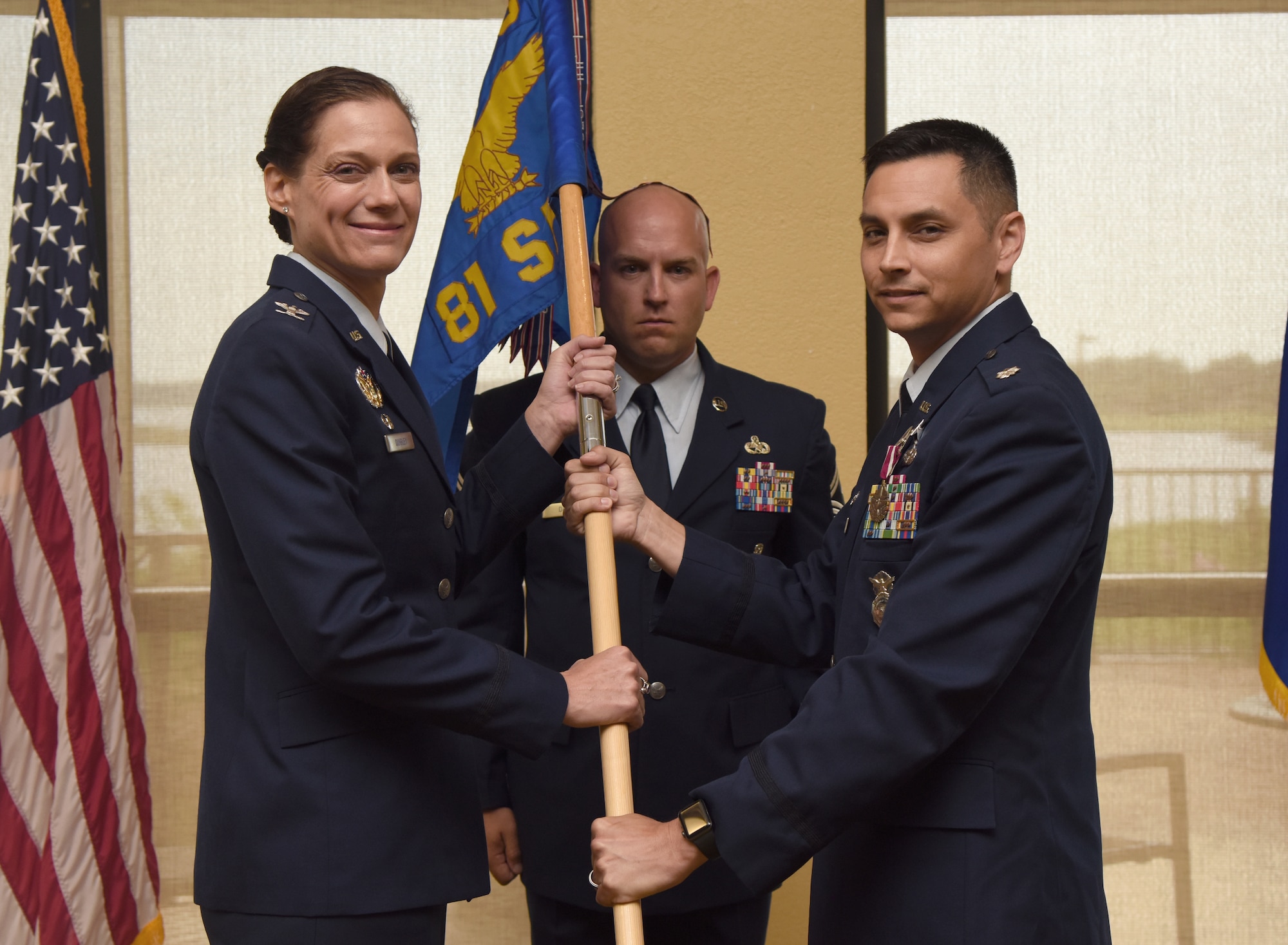 U.S. Air Force Col. Marcia Quigley, 81st Mission Support Group commander, takes the 81st Security Forces Squadron guidon from Lt. Col. Jonathon Murray, outgoing 81st SFS commander, during the 81st SFS change of command ceremony inside the Bay Breeze Event Center at Keesler Air Force Base, Mississippi, May 31, 2019. The passing of the guidon is a ceremonial symbol of exchanging command from one commander to another. (U.S. Air Force photo by Kemberly Groue)