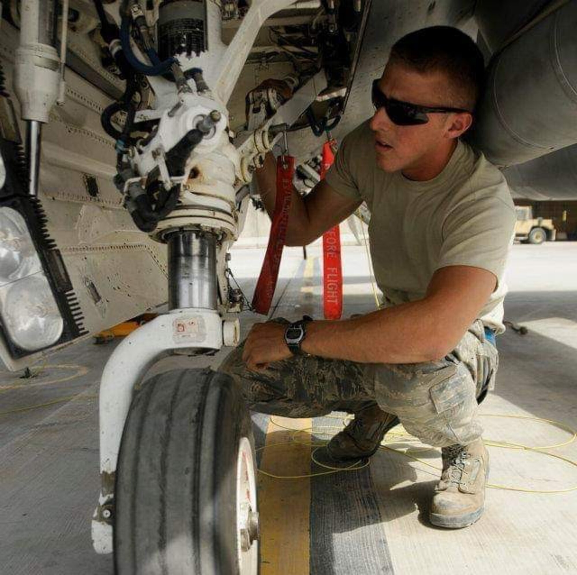 An Airman works on the landing gear of an F-16 Fighting Falcon  fighter jet.