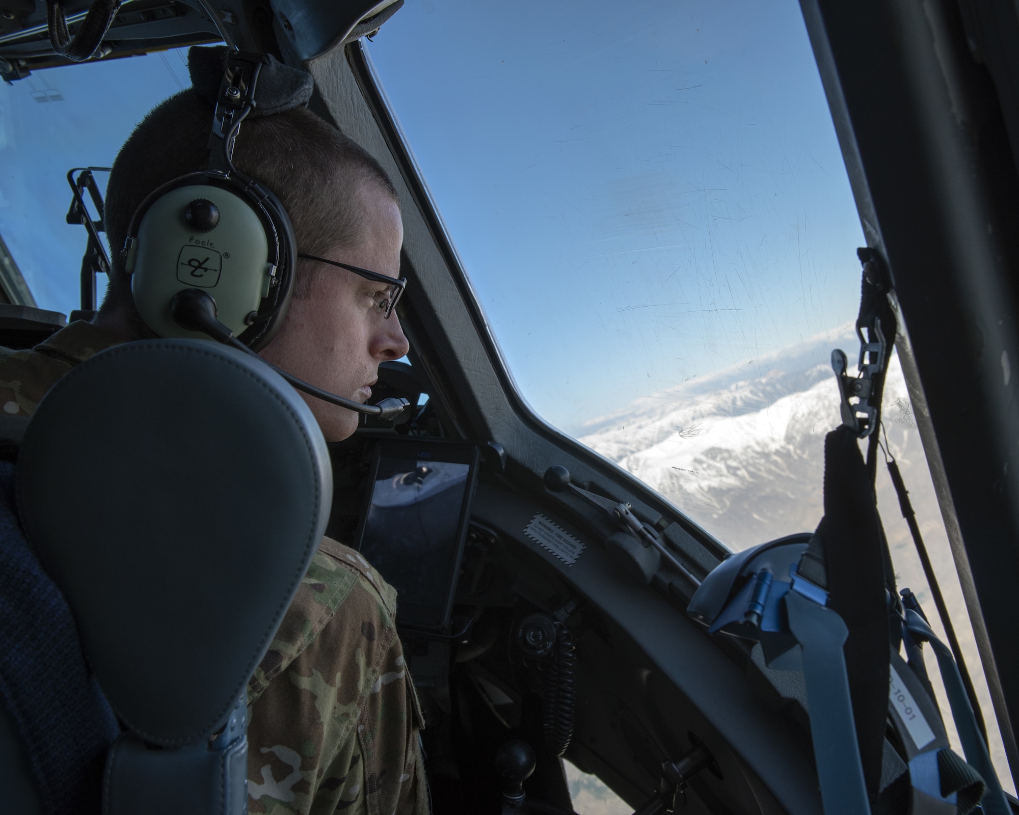 U.S. Air Force Capt. Justin Poole, 21st Airlift Squadron pilot, scans the landscape outside Bagram Airfield, Afghanistan in a C-17 Globemaster III, May 26, 2019. The C-17 is capable of rapid strategic delivery of troops and cargo anywhere in the world. (U.S. Air Force photo by Tech. Sgt. Traci Keller)