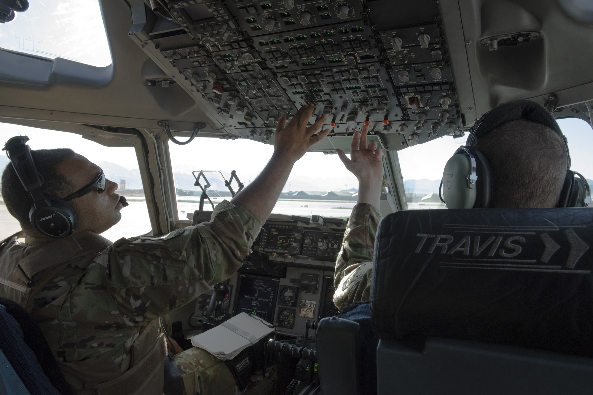 U.S. Air Force Maj. Roger Gates, left, and Capt. Justin Poole, 21st Airlift Squadron pilots, perform preflight checks in a C-17 Globemaster III prior to takeoff from Bagram Airfield, Afghanistan, May 26, 2019. The C-17 is capable of rapid strategic delivery of troops and cargo anywhere in the world. (U.S. Air Force photo by Tech. Sgt. Traci Keller)