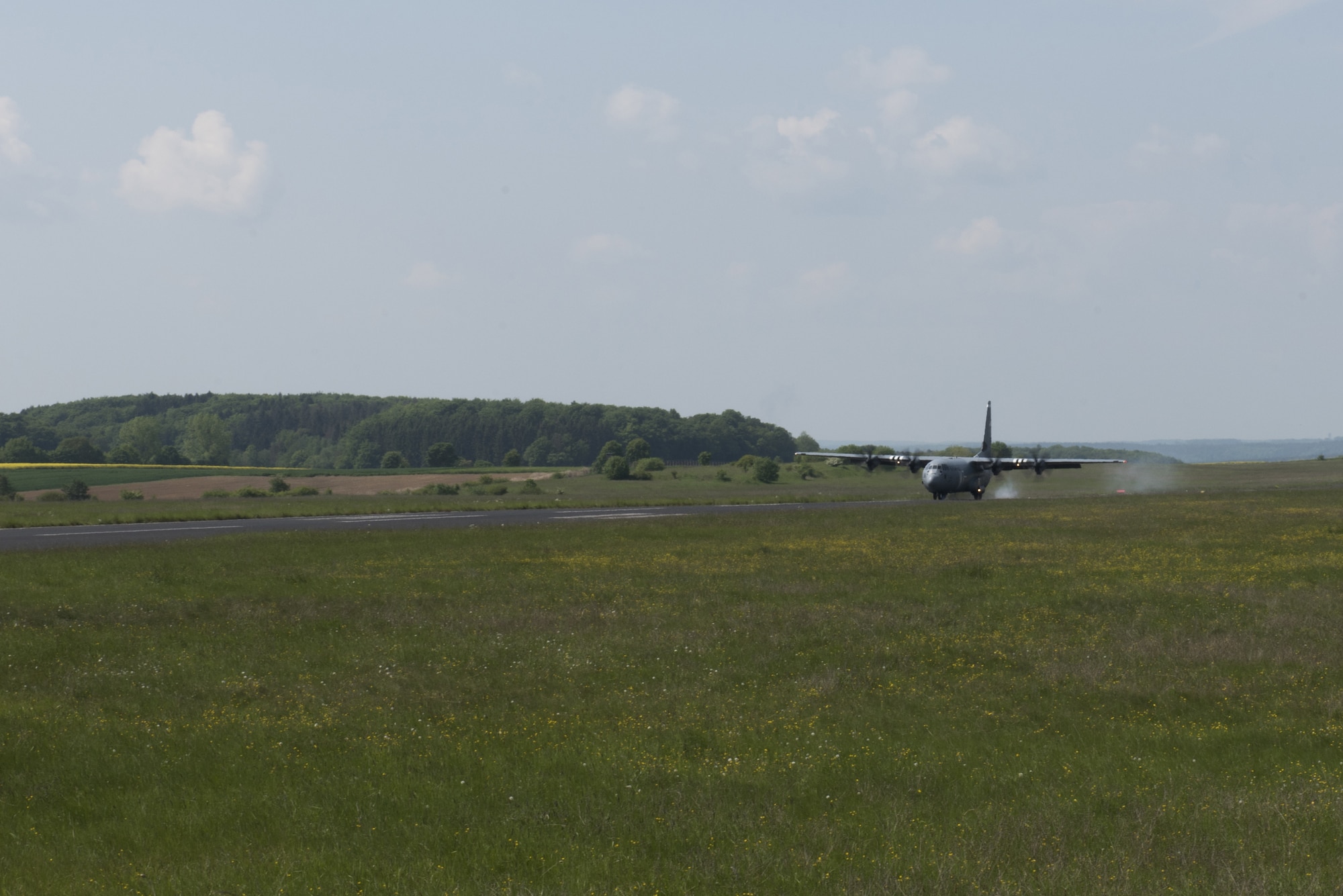 A C-130J touches down on a landing zone prepared by students of the Landing Zone Safety Officer course at Bitburg Airfield, Germany, May 23, 2019. Students surveyed the area, evaluated the pavement, marked the landing zone with panels and communicated with the aircraft via radio. (U.S. Air Force Photo by Airman 1st Class Kaylea Berry)