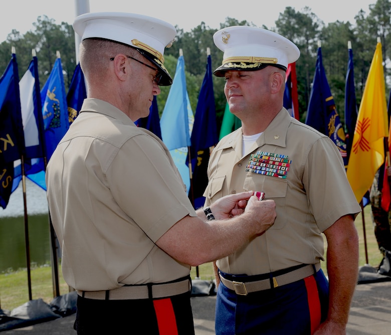 Maj. Will H. Anderson, right, deputy director, Supply Integration Division, Logistics Services Management Center, MARCORLOGCOM, receives the Meritorious Service Medal from Maj.Gen. Joseph F. Shrader, commanding general, MARCORLOGCOM, during a ceremony held at Covella Pond aboard MARCORLOGBASES Albany, GA., May 31. Anderson served over 30 years in the Marine Corps.