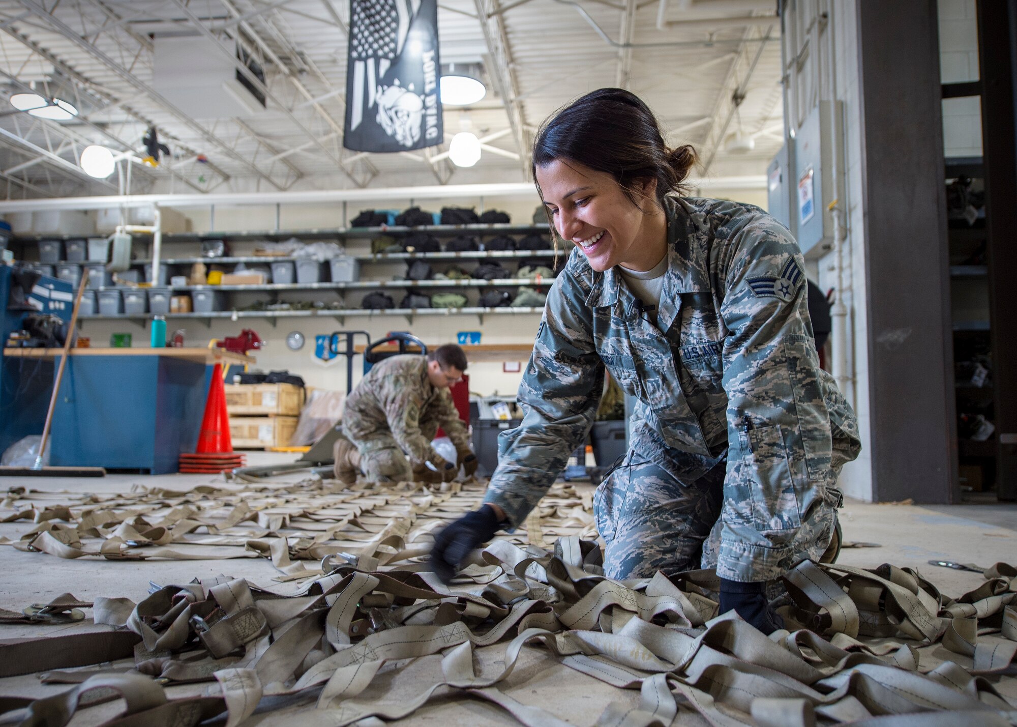U.S. Air Force Senior Airman Marissa Ricci, from the 133rd Small Air Terminal, lays out cargo straps to secure palletized boxes of food in St. Paul, May 18, 2019.