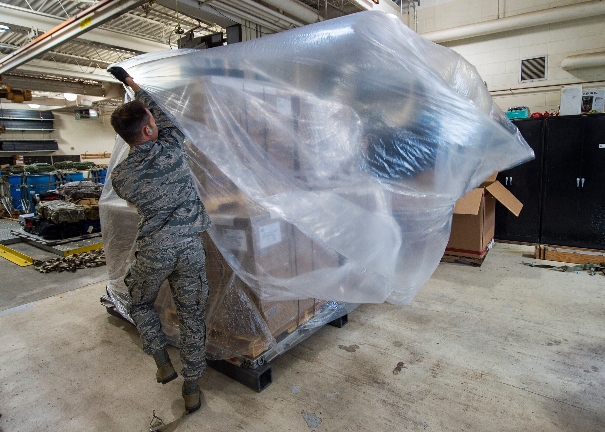 U.S. Air Force Tech. Sgt. Corry Freeman, from the 133rd Small Air Terminal, covers a pallet of food with plastic in St. Paul, May 18, 2019.