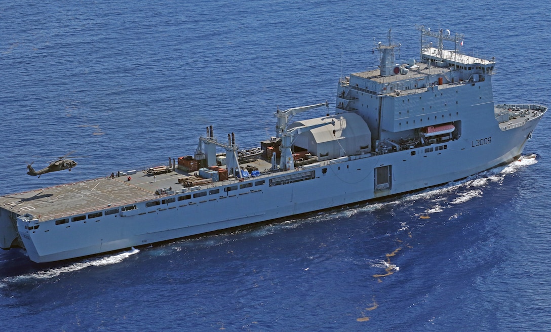 A helicopter lands on a ship.