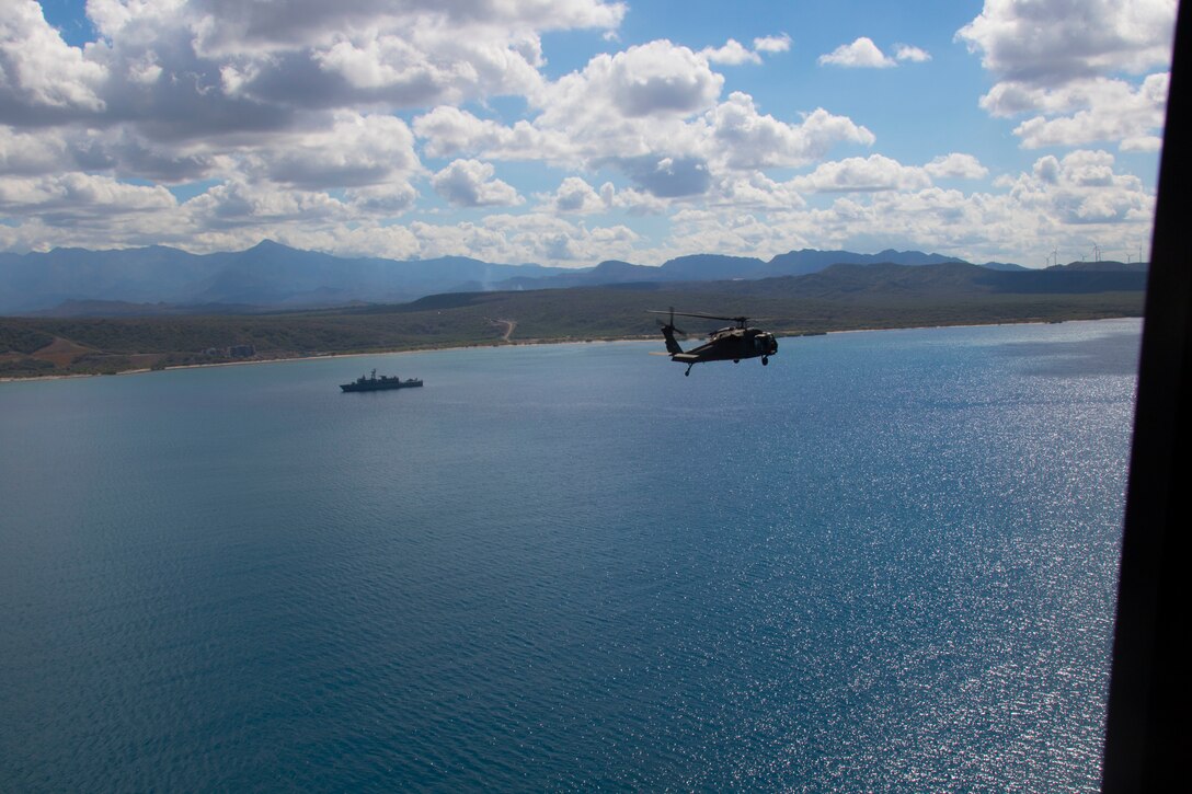 A helicopter prepares to land on a ship.
