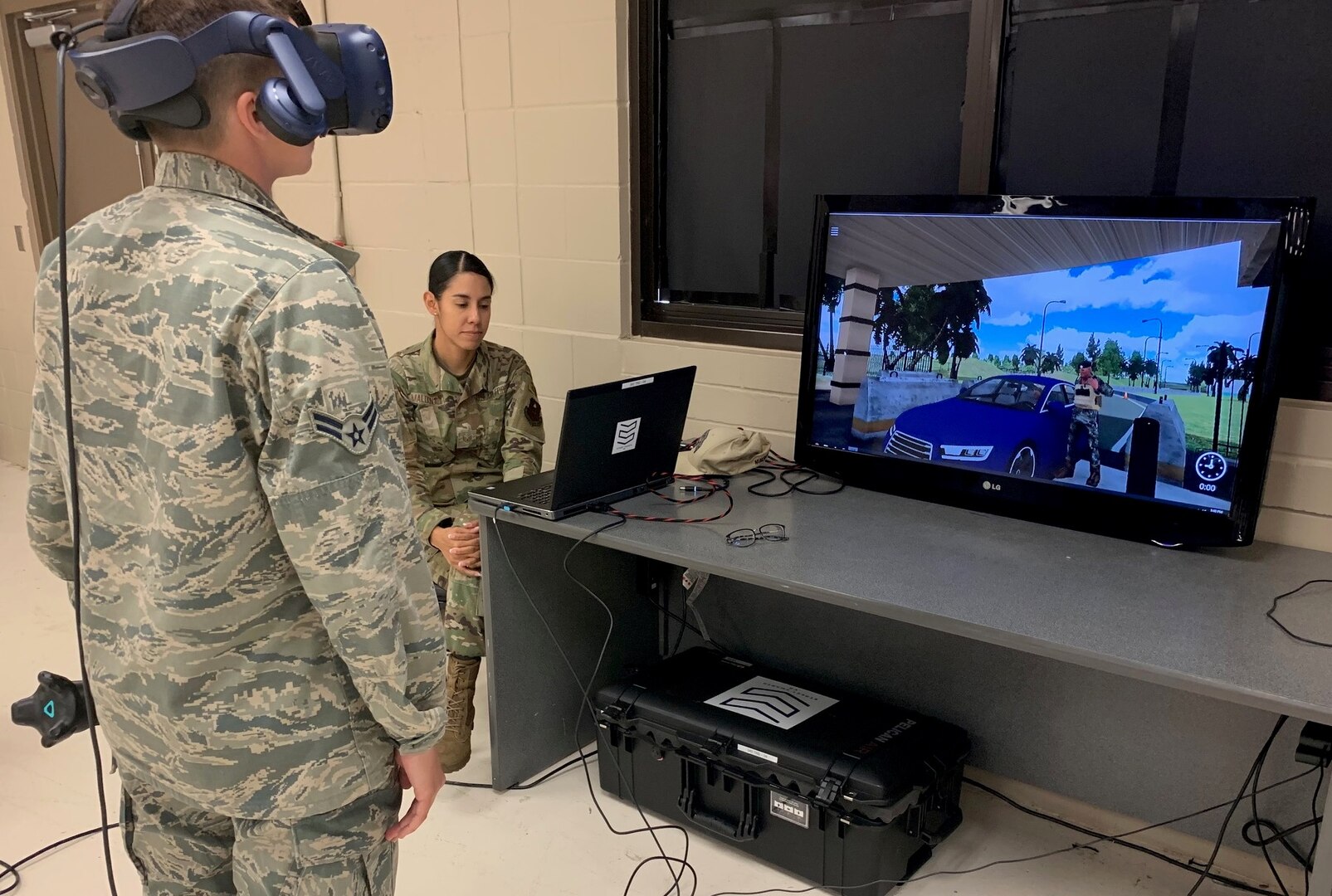 Airman 1st Class Taylor Waldron, a recent graduate of the Security Forces apprentice course, participates in a use of force training scenario in virtual reality environment simulator as Staff Sgt. Marcia Maldonado, 343rd Training Squadron instructor, facilitates training at Joint Base San Antonio-Lackland May 29. The 343rd Training Squadron has added the VR training simulators as part of a beta-test in conjunction with a civilian vendor at no cost to the unit through a partnership with AFWERX.