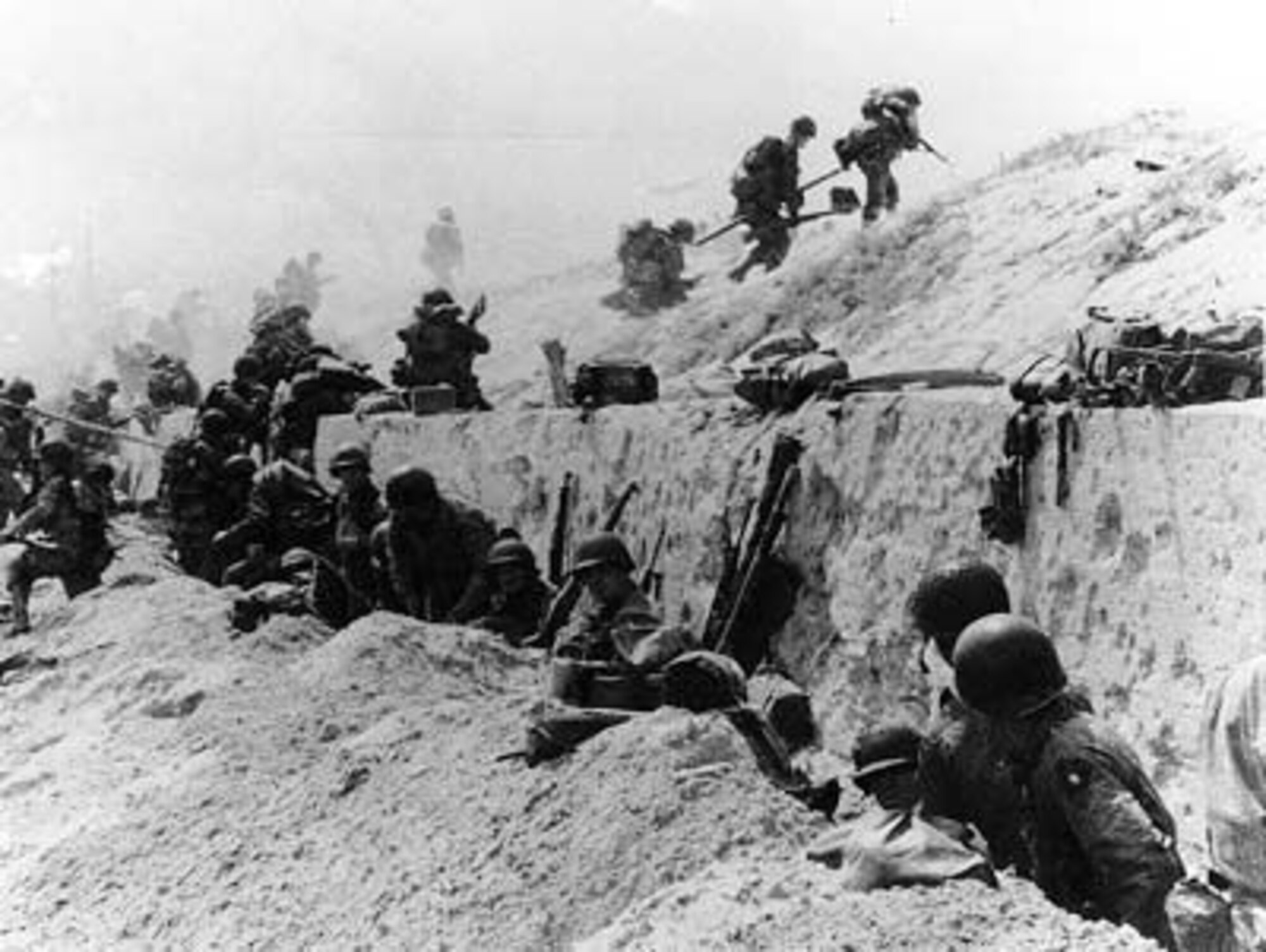 U.S. Soldiers of the 8th Infantry Regiment, 4th Infantry Division, move out over the seawall on Utah Beach, after coming ashore.