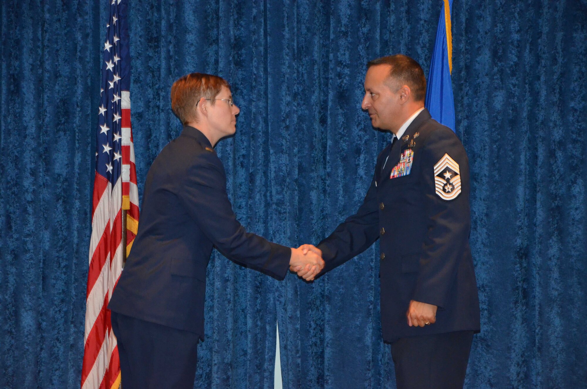 Chief Master Sgt. Michael Joseph, command chief for the Air Force Technical Applications Center at Patrick AFB, Fla., shakes hands with newly-commissioned 2nd Lt. Cynthia A. Schroll, immediately after Schroll presented the chief with a silver dollar after rendering the traditional first salute at Officer Training School May 30, 2019.  (U.S. Air Force photo by Susan A. Romano)