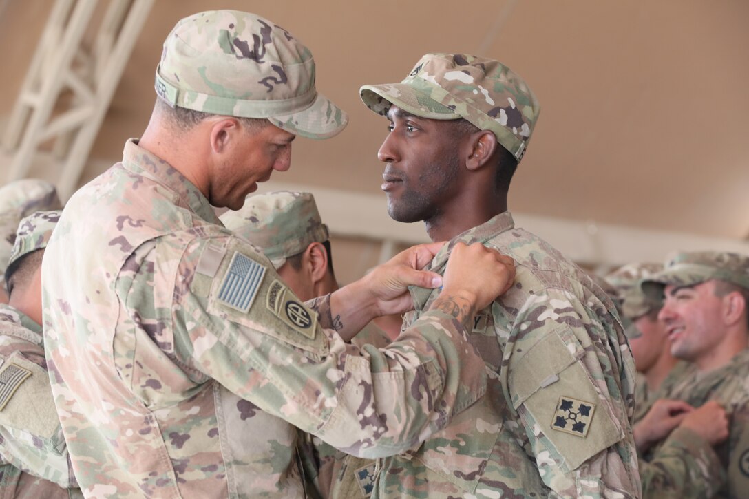 Staff Sgt. Stephen Frazier, an infantryman in 1st Battalion, 66th Armor Regiment, 3rd Armored Brigade Combat Team, 4th Infantry Division, is pinned with an Expert Infantryman Badge during a ceremony at Camp Buehring, Kuwait on Saturday, June 1, 2019. Frazier and 60 other infantry Soldiers deployed throughout the U.S. Army Central area of operations earned their EIB after completing a week of thorough testing with 3rd ABCT at Camp Buehring.