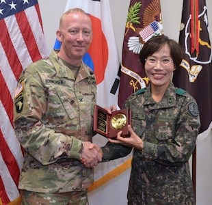 Col. Daniel Bonnichsen, U.S. Army Medical Department Center & School, Health Readiness Center of Excellence chief of staff and Republic of Korea Army Brigadier General Myoung-ok Kwon, superintendent for the Korea Armed Forces Nursing Academy, conduct a gift exchange during a visit to Joint Base San Antonio-Fort Sam Houston May 30.