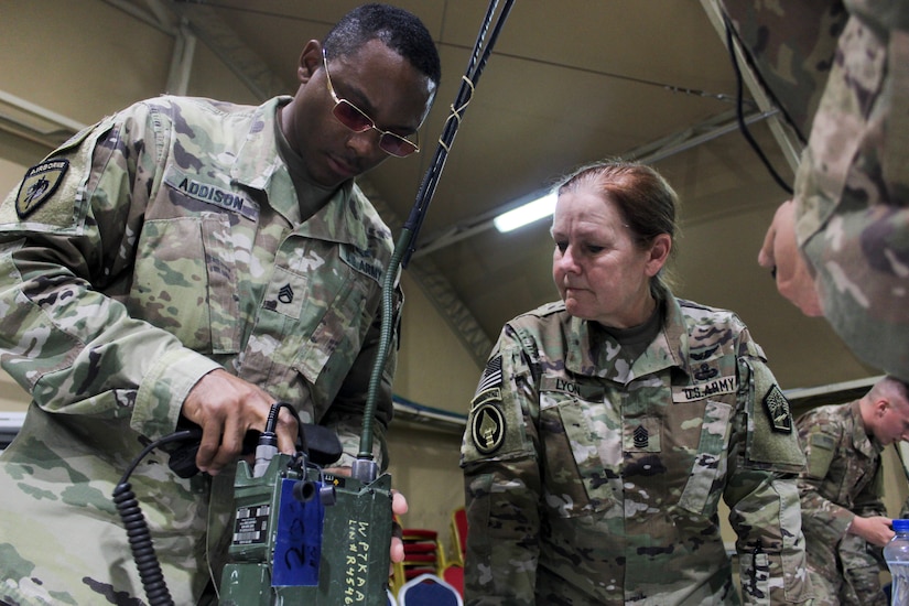 Command Sgt. Maj. Sheryl Lyon, U.S. Army Cyber Command senior enlisted leader, observes as Staff Sgt. Sir Addison, network management NCO-in-charge for the Regional Cyber Center-Southwest Asia (RCC-SWA), assembles and operates a radio as part of the U.S. Army Central  2019 Best Cyber Warrior Competition, at Camp Arifjan, Kuwait, May 14, 2019 .  The three-day, joint, multinational competition, highlighted the readiness and teamwork of the forces defending the U.S. in the cyber domain.