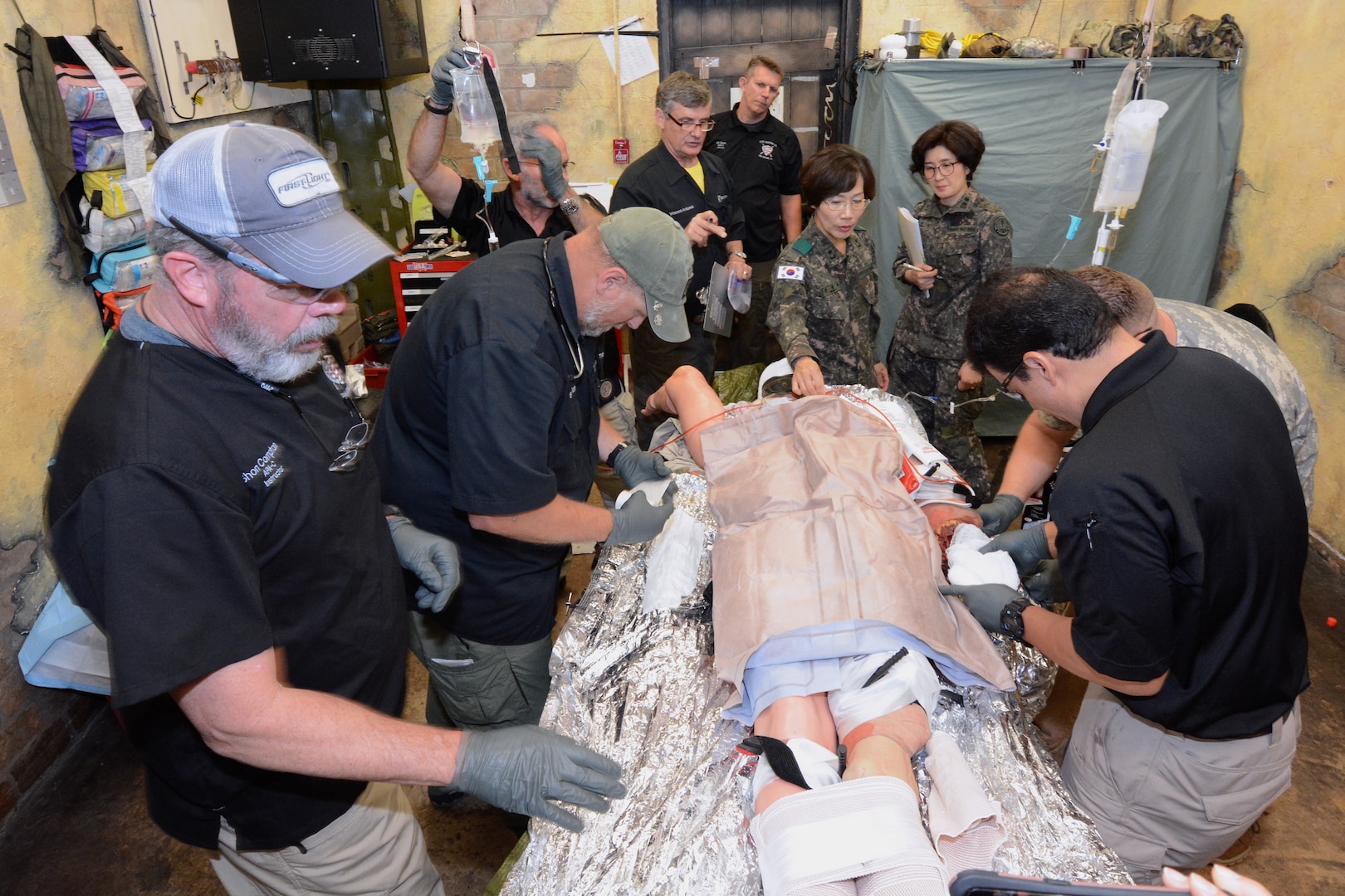 Republic of Korea Army Brig. Gen. Myoung-ok Kwon (center), superintendent for the Korea Armed Forces Nursing Academy, observes a live demonstration of a combat trauma management scenario in a mock aid station conducted by instructors for the U.S. Army Medical Department Center & School, Health Readiness Center of Excellence’s Tactical Combat Medical Care course during a May 2019 visit to Joint Base San Antonio-Fort Sam Houston.  Also pictured (to her right) is ROK Army Lt. Col. Yoomi Jung, director for the Academy’s Clinical Nursing Science Department.