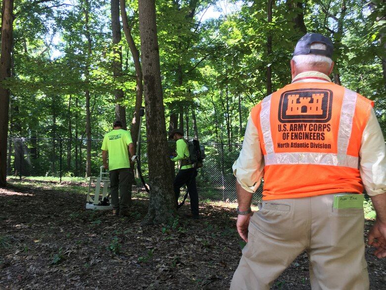 U.S. Army Corps of Engineers Project Manager Alex Zahl looks on as contractors use Advanced Geophysical Classification technology to identify potentially buried munitions items on a municipally owned parcel of property along the Dalecarlia Parkway within the boundaries of the Spring Valley Formerly Used Defense Site in Washington, D.C., Sept. 6, 2018. The Corps is using the latest in geophysical mapping technology to reduce the amount of unnecessary digs during its munitions investigation where cultural debris like scrap metal, nails and other construction debris make up the majority of the digs on site.