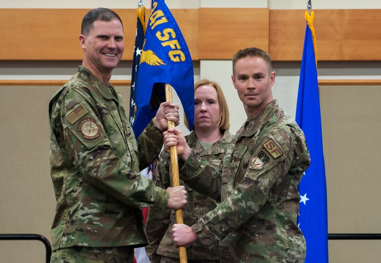 Maj. Brian Gilliam, right, accepts command of the 741st Missile Security Forces Squadron from Col. Aaron Guill, 341st Security Forces Group commander during a change of command ceremony June 4, 2019, at the Grizzly Bend on Malmstrom Air Force Base, Mont