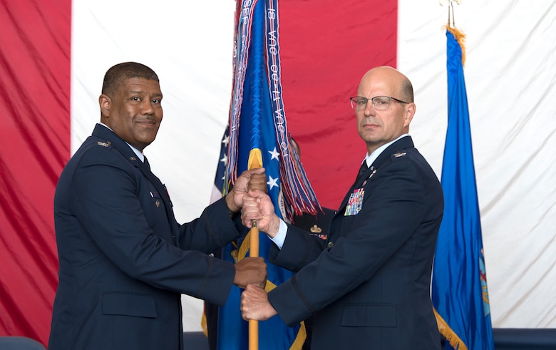 Col. Raymond Kozak, outgoing 349th Air Mobility Wing commander, passes the guidon to Col. Robert Blake, 4th Air Force vice commander, during a change of command ceremony at Travis Air Force Base, California, June 1, 2019. Col. Scott McLaughlin is schedule to assume command of the 349th AMW from Kozak on June 9.