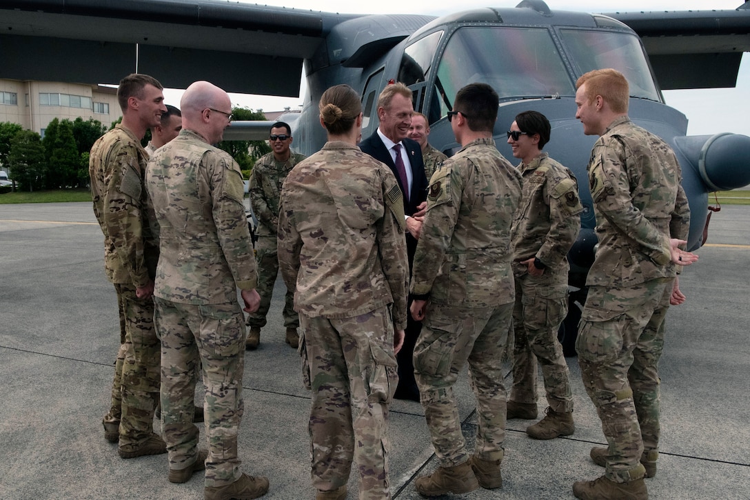 Acting Defense Secretary Patrick M. Shanahan meets with airmen in front of a military aircraft.