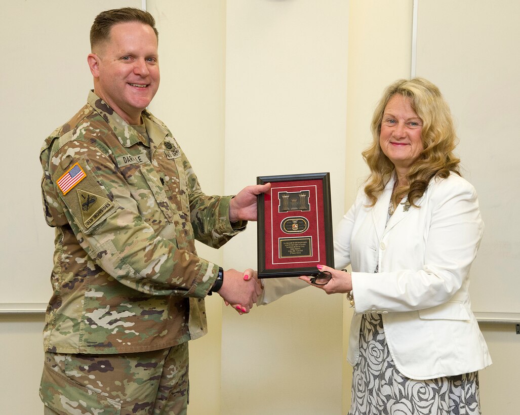 Lt. Col. Hugh Darville, Huntsville Center commander, presents Sandi Zebrowski with a token of appreciation during a retirement ceremony at Huntsville Center in May. Zebrowski served as the director of the Center's Environmental and Munitions Center of Expertise since 2008.