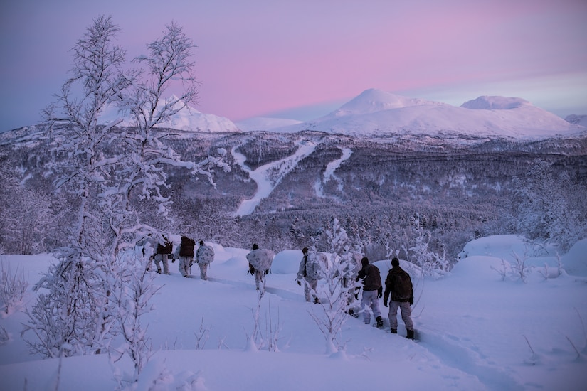 Marines and soldiers patrol at dusk.