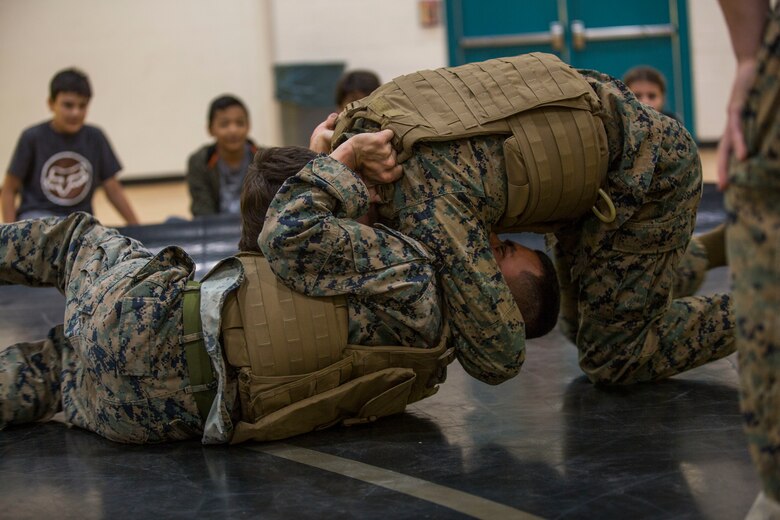 U.S. Marines assigned to Marine Air Control Squadron (MACS) 1 participate in MACS-1's Marine Week at Ron Watson Middle School in Yuma, Ariz., March 27, 2019. The first day of Marine Week consisted of opening remarks from the MACS-1 Commanding Officer, Lt. Col. David Hughes, and demonstrations of the Marine Corps Martial Arts Program (MCMAP) techniques. (U.S. Marine Corps photo by Cpl. Sabrina Candiaflores)