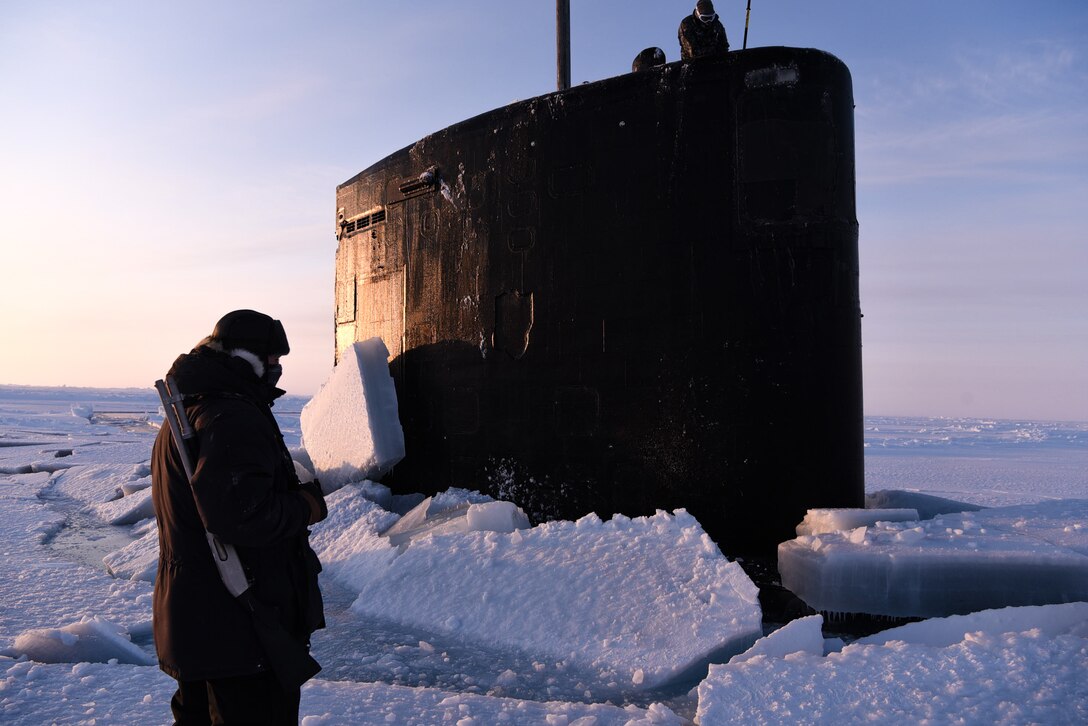 A submarine conning tower sticks through Arctic ice.