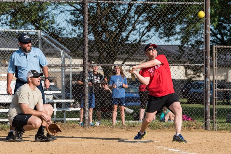 Col. Tyler Schaff, 436th Mission Support Group commander, gets ready to swing at a pitch during the Chiefs versus Colonels softball game June 3, 2019, at Dover Air Force Base, Del. Playing catcher, Chief Master Sgt. Anthony Green, 436th Airlift Wing command chief, led the Chiefs to a 16-15 win over the Colonels. (U.S. Air Force photo by Roland Balik)