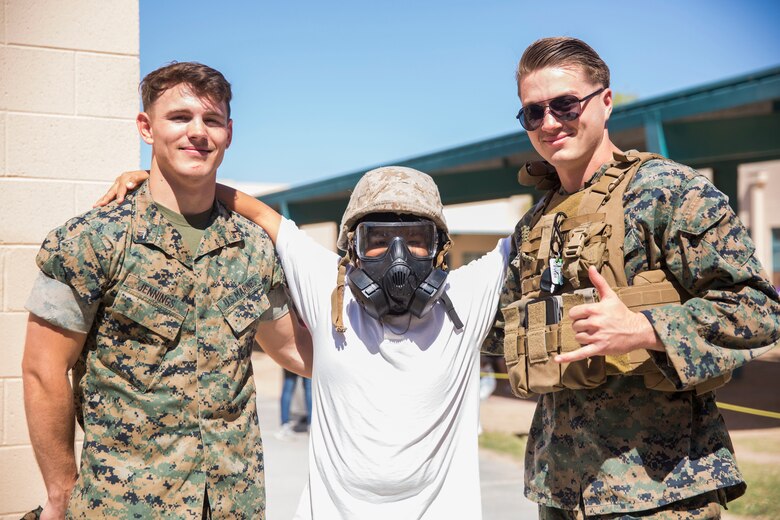 U.S. Marines assigned to Marine Air Control Squadron (MACS) 1 participate in MACS-1's Marine Week at Ron Watson Middle School in Yuma, Ariz., March 29, 2019. The third and last day of Marine Week consisted of students conducting a modified Combat Fitness Test, tasting food from Meal, Ready-to-Eat (MRE), trying on Marine Corps equipment; flak jackets, gas masks, etc., and interacting with the Marines. (U.S. Marine Corps photo by Cpl. Sabrina Candiaflores)