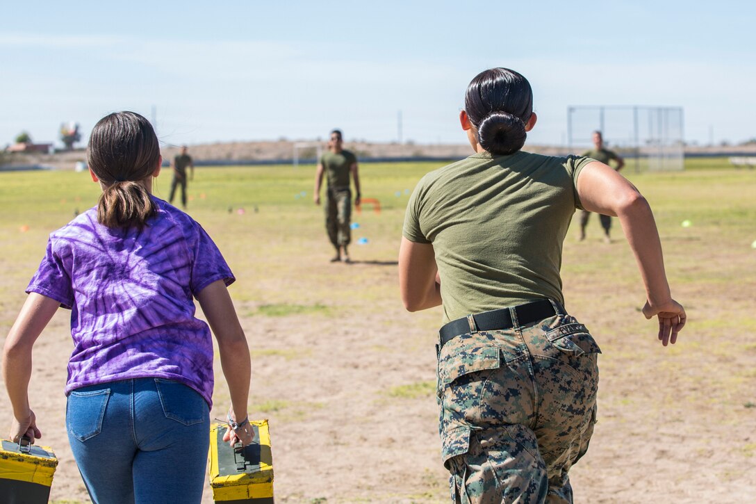 U.S. Marines assigned to Marine Air Control Squadron (MACS) 1 participate in MACS-1's Marine Week at Ron Watson Middle School in Yuma, Ariz., March 29, 2019. The third and last day of Marine Week consisted of students conducting a modified Combat Fitness Test, tasting food from Meal, Ready-to-Eat (MRE), trying on Marine Corps equipment; flak jackets, gas masks, etc., and interacting with the Marines. (U.S. Marine Corps photo by Cpl. Sabrina Candiaflores)