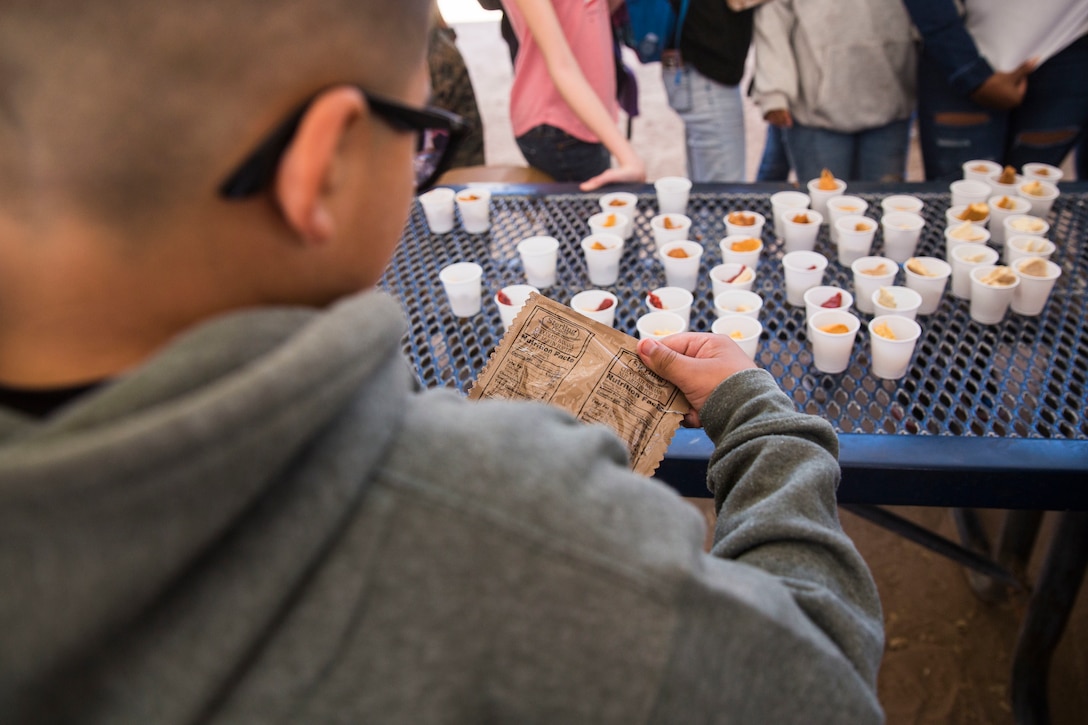 U.S. Marines assigned to Marine Air Control Squadron (MACS) 1 participate in MACS-1's Marine Week at Ron Watson Middle School in Yuma, Ariz., March 29, 2019. The third and last day of Marine Week consisted of students conducting a modified Combat Fitness Test, tasting food from Meal, Ready-to-Eat (MRE), trying on Marine Corps equipment; flak jackets, gas masks, etc., and interacting with the Marines. (U.S. Marine Corps photo by Cpl. Sabrina Candiaflores)