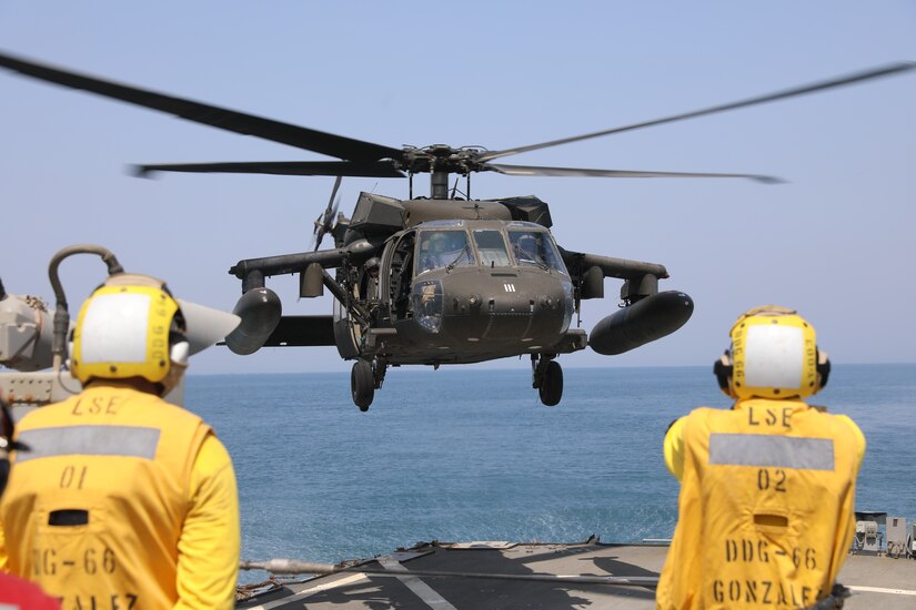 A U.S. Navy Sailor guides a U.S. Army UH-60 Black Hawk helicopter assigned to Bravo Company, 2nd Battalion, 147th Aviation Regiment, 8th Battalion, 229th Aviation Regiment during deck landing qualifications aboard the Arleigh Burke-class guided-missile destroyer USS Gonzalez (DDG 66), May 22, 2019 in the Arabian Gulf. The Gonzalez deployed to the U.S. Central Command area of operations to strengthen security and stability of the region. Deck landing qualifications increase interoperability between U.S Army and Navy personnel.