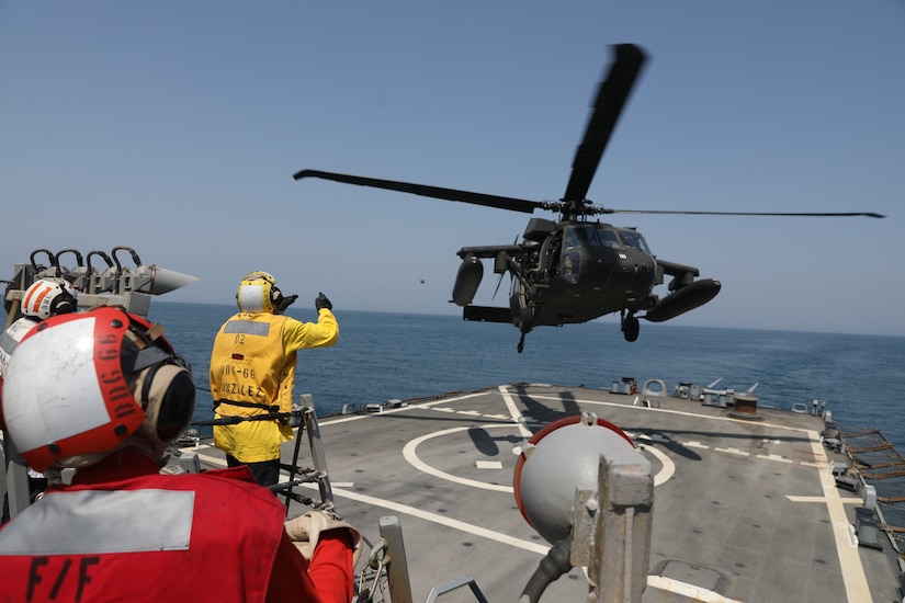 A U.S. Navy Sailor guides a U.S. Army UH-60 Black Hawk helicopter assigned to Bravo Company, 2nd Battalion, 147th Aviation Regiment, currently attached to 8th Battalion, 229th Assault Helicopter Battalion, in for a deck landing qualification aboard the Arleigh Burke-class guided-missile destroyer USS Gonzalez (DDG 66), May 22, 2019 in the Arabian Gulf. The Gonzalez deployed to the U.S. Central Command area of operations to strengthen security and stability of the region. The deck landing qualifications were held to increase interoperability between U.S Army and Navy personnel.