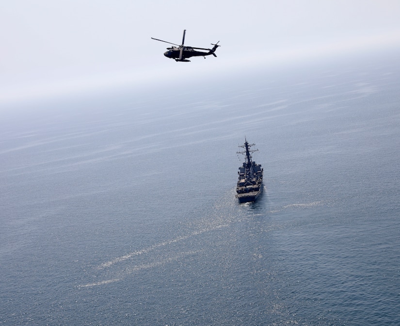 A U.S. Army UH-60 Black Hawk helicopter, assigned to Bravo Company, 2nd Battalion, 147th Aviation Regiment currently attached to 8th Battalion, 229th Assault Helicopter Battalion, flies over the Arleigh Burke-class guided-missile destroyer USS Gonzalez (DDG 66), May 22, 2019 in the Arabian Gulf. The Gonzales is deployed to the U.S. Central Command area of responsibility to help provide security and stability in the region.