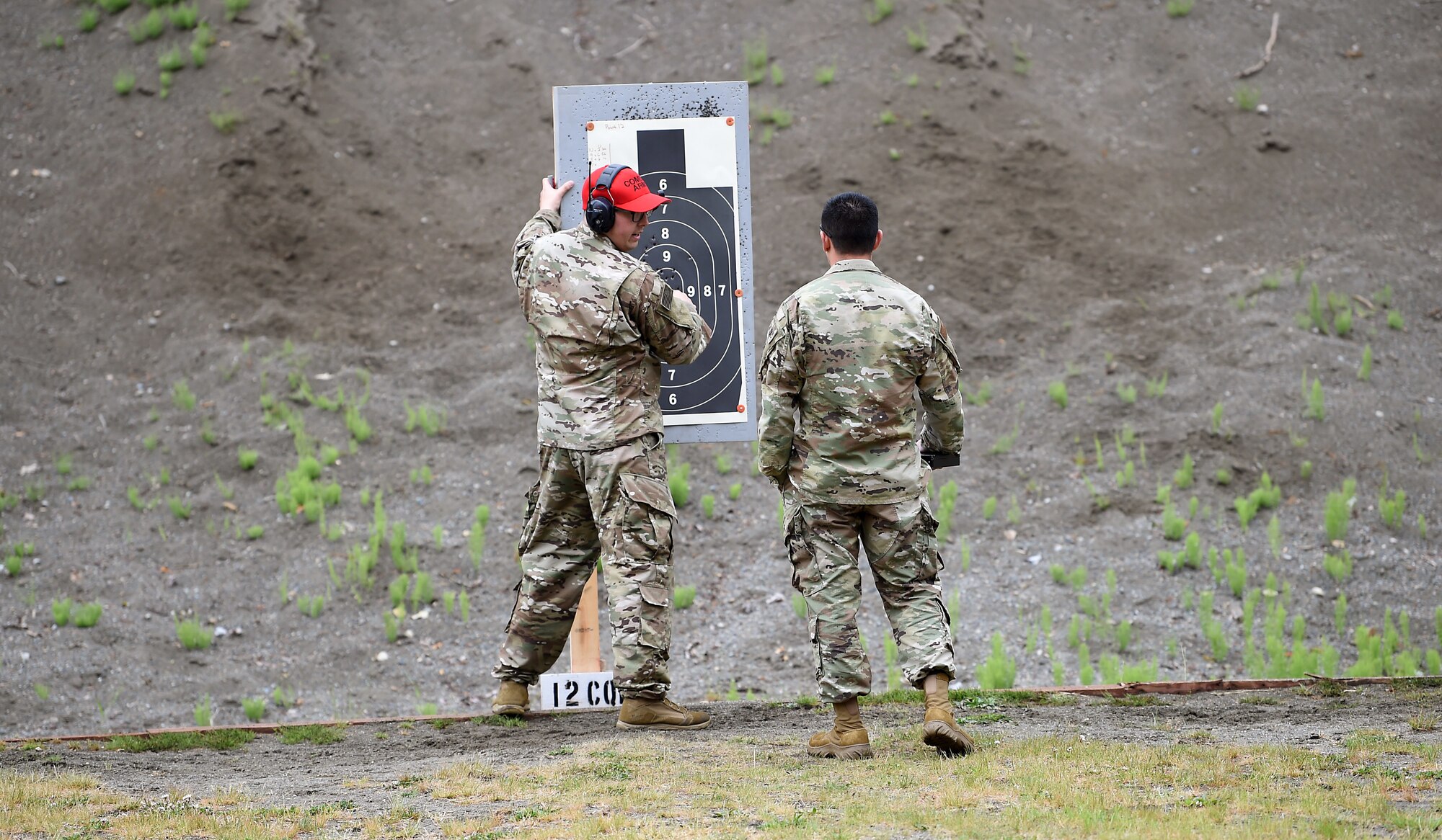Staff Sgt. Jordan Covington, 627th Security Forces Squadron combat arms instructor, counts the shots made on the target by Tech. Sgt. Daniel Paredes, 5th Air Support Operations Squadron non-commissioned officer in charge of interface control, during the Excellence in Competition (EIC) for M9 match as part of Police Week on Joint Base Lewis-McChord, May 16, 2019.