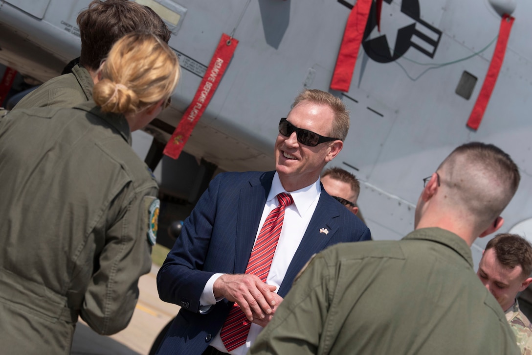 Acting Defense Secretary Patrick M. Shanahan talks with troops on a flightline.