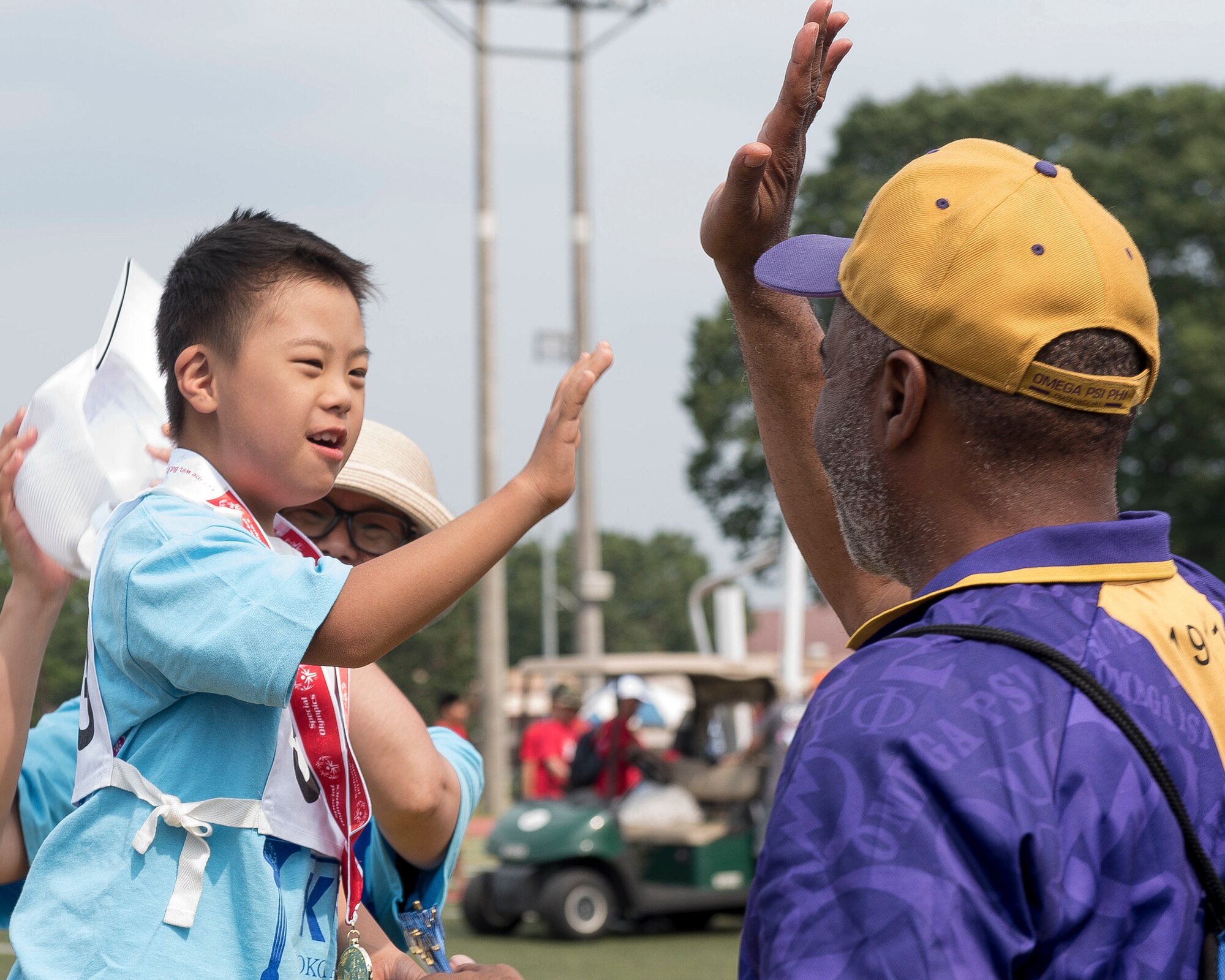 An athlete exchanges a high-five with a medal presenter after receiving a medal during the 40th Annual Kanto Plains Special Olympics at Yokota Air Base Japan, June 1, 2019.