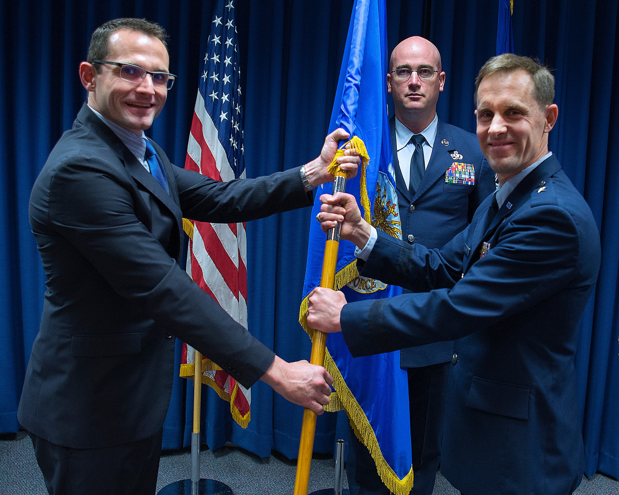 Dr. Will Roper, U.S. Air Force Assistant Secretary for Acquisition, Technology and Logistics, presents Brig. Gen. John P. Newberry with a guidon, May 31, 2019 as Newberry assumes leadership of the directorate during a ceremony at Wright-Patterson Air Force Base Ohio. Senior Master Sgt. Shawn R. Akers, Tanker Directorate superintendent stands by to take the guidon from Newberry. (U.S. Air Force photo by R.J. Oriez)