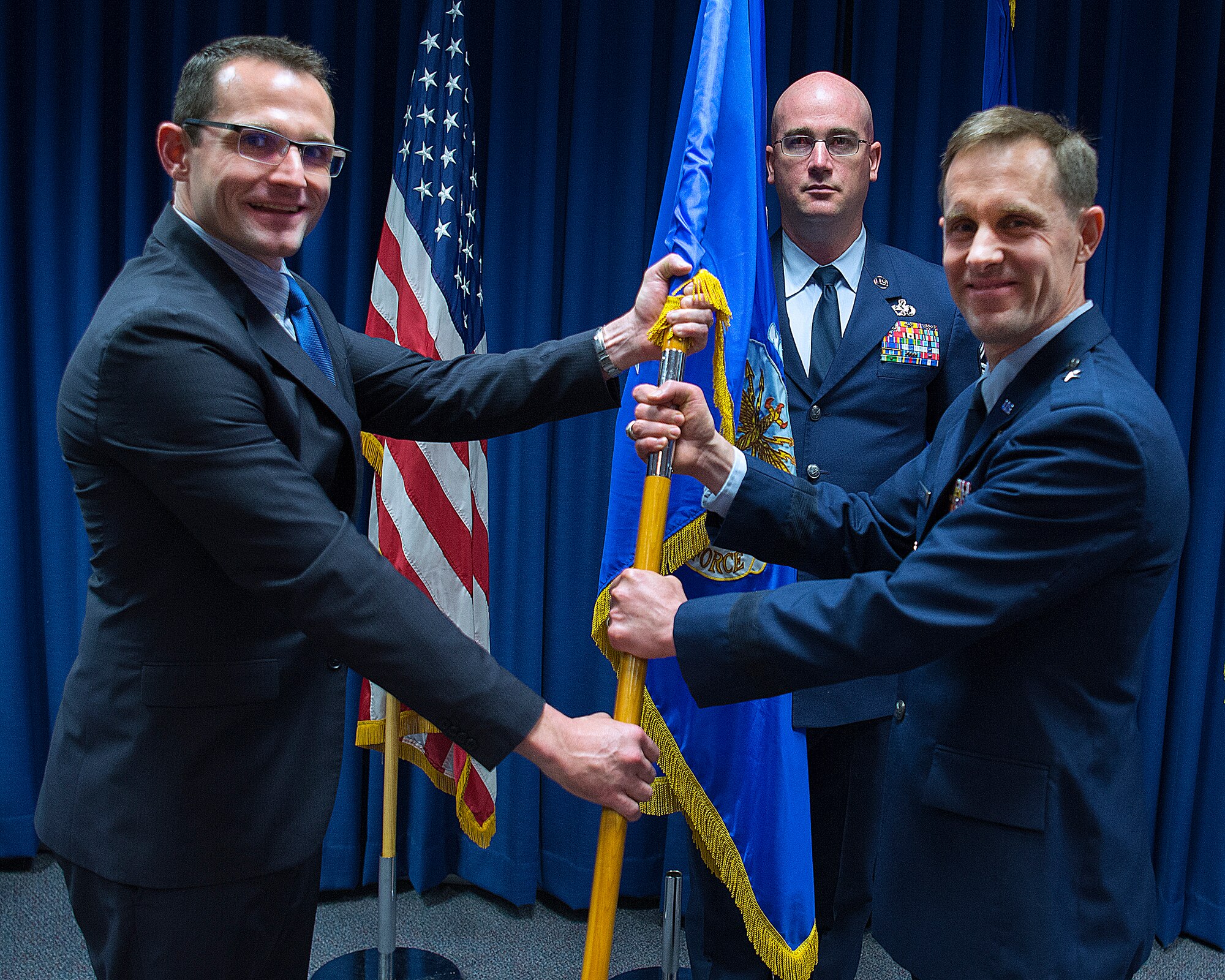 Dr. Will Roper, U.S. Air Force Assistant Secretary for Acquisition, Technology and Logistics, presents Brig. Gen. John P. Newberry with a guidon, May 31, 2019 as Newberry assumes leadership of the directorate during a ceremony at Wright-Patterson Air Force Base Ohio. Senior Master Sgt. Shawn R. Akers, Tanker Directorate superintendent stands by to take the guidon from Newberry. (U.S. Air Force photo by R.J. Oriez)