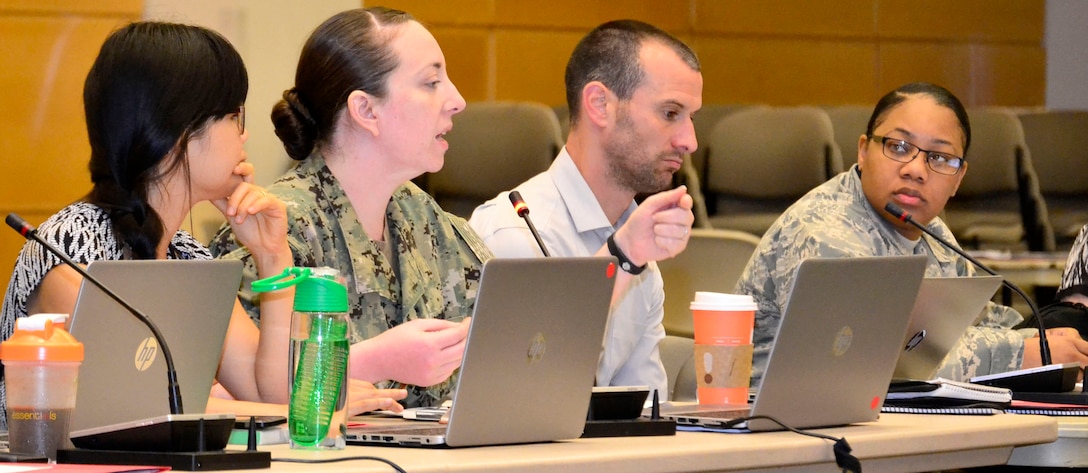 Navy Lt. Cmdr. Kyleigh Hupfl, a DLA Troop Support Medical supply chain pharmacist, middle left, speaks during a hurricane exercise at DLA Troop Support May 28, 2019 in Philadelphia.