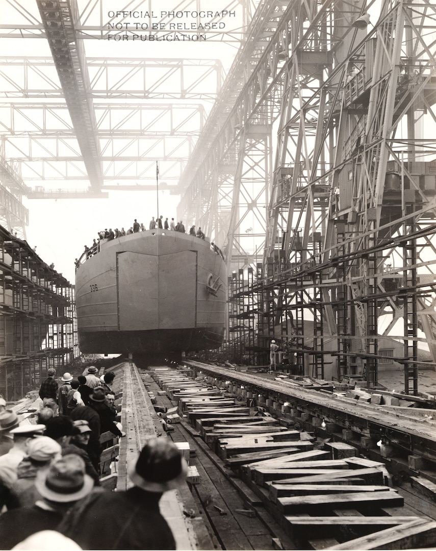 Among the five classes of ships NNSY built or modernized to support the invasion of Normandy on June 6, 1944, the shipyard built 20 tank landing ships (LSTs), numbered LST-333 though LST-352. With each weighing in around 1,625 tons, these ships could traverse the ocean’s depths and also navigate shallow draft for moving troops, tanks and other equipment ashore.  Their unique design featured a large door at the bow of the ship for the convenient unloading of vehicles, with no dock or pier required to engage in full assaults.  Another distinguishing characteristic was their flat keels so they wouldn’t capsize on land.  LSTs took part in the full range of World War II’s amphibious operations in Europe and the Pacific.