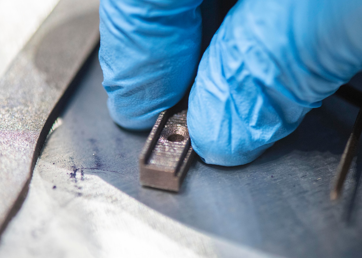 A 3-dimensional metal piece part is presented on Naval Surface Warfare Center Panama City Division's new addition of an EOS M290 Direct Metal Laser Sintering printer. .