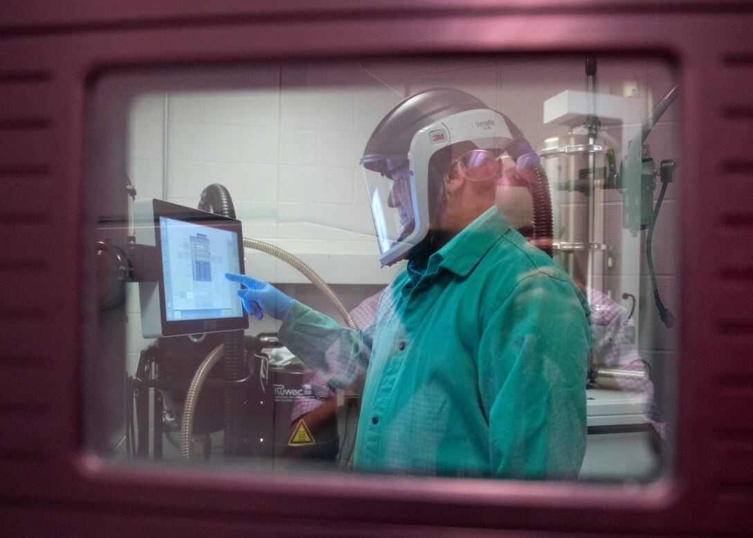 Chuck Self, Naval Surface Warfare Center Panama City Division additive manufacturing laboratory head, prepares the EOS M290 Direct Metal Laser Sintering printer.