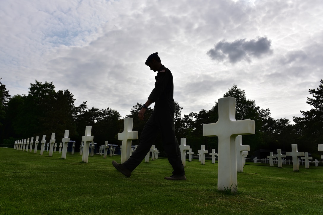 An Aimran walks through a military cemtery