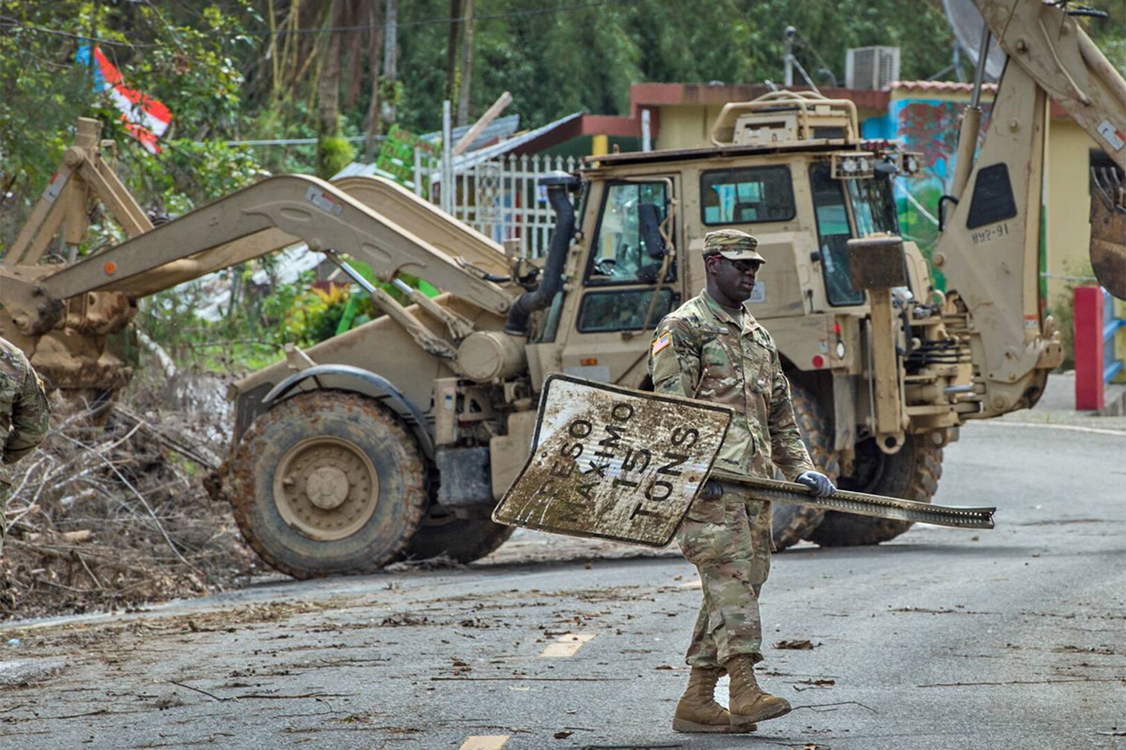 A South Carolina National Guard Soldier with Task Force Palmetto, helps clear a road in the vicinity of Cayey, Puerto Rico. The Soldiers are working in conjunction with the 190th Engineer Battalion of the Puerto Rico National Guard to clear mud and debris from the roads in the wake of Hurricane Maria and subsequent rain storms.