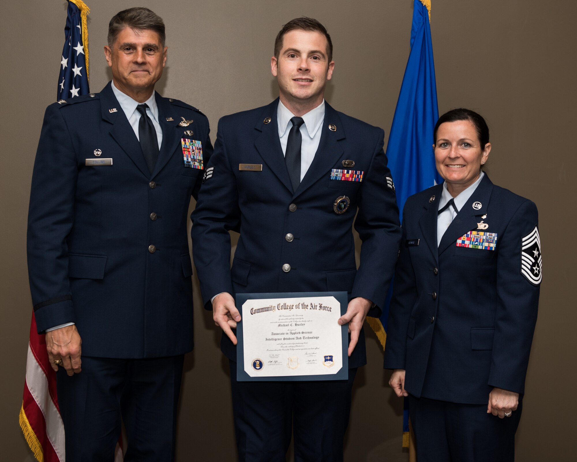 Senior Airmen Michael Hurley, with the 932nd Airlift Wing, receives his Community College of the Air Force associate degree in applied science certificate from 932nd AW commander, Col. Glenn Collins during a CCAF graduation ceremony, June 2, 2019, Scott Air Force Base, Illinois. Wing leadership and fellow Airmen joined the graduates to celebrate their higher education accomplishment. (U.S. Air Force photo by Master Sgt. Christopher Parr)