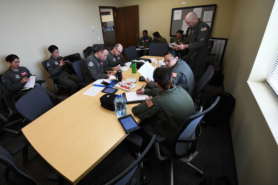 Airmen sit in briefing room